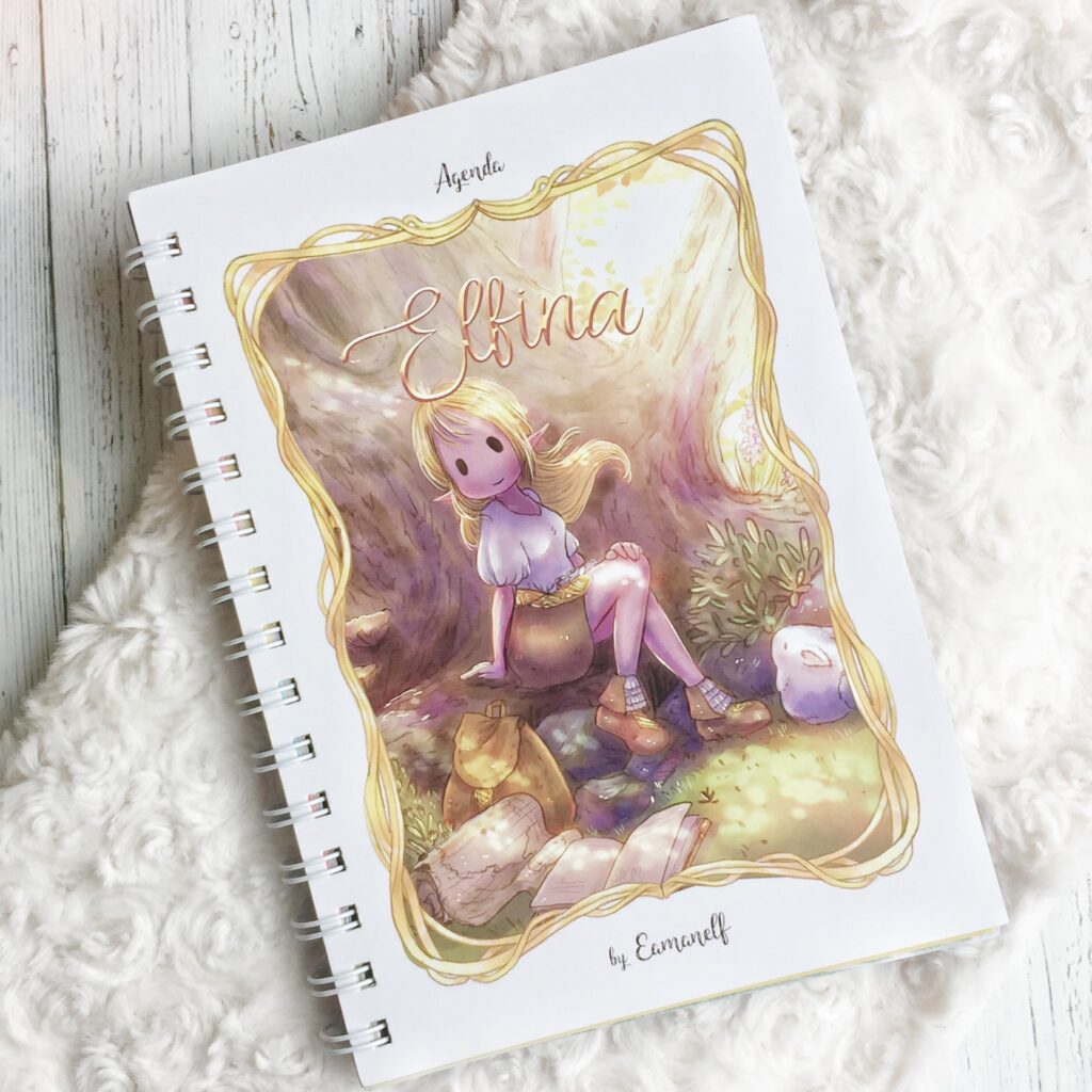 Portada de la agenda elfina ilustrada por eamanelf donde la protagonista elfi la elfa esta sentada sobre un tronco junto a su conejo mascota